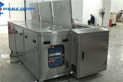 How does the automatic ultrasonic spray cleaning machine clean the products?
